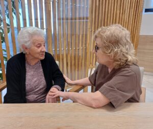 Persona mayor con su familia evaluando opciones de cuidado en casa o en residencia de ancianos