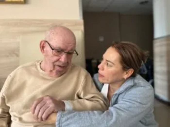 Trabajadora de la residencia de ancianos La Vostra Llar ayudando a un adulto mayor